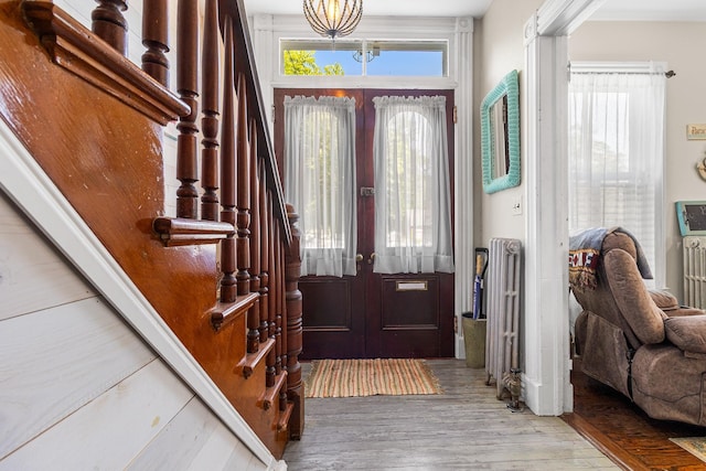 30 Railroad Ave, Center Moriches, NY 11934 - foyer featuring french doors, wood finished floors, radiator heating unit, and stairs