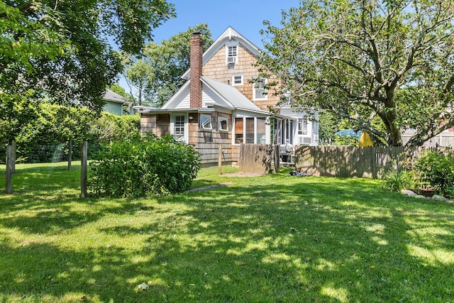 30 Railroad Ave, Center Moriches, NY 11934 - rear view of house with a chimney and a sunroom