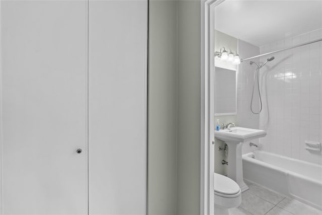 bathroom featuring tile patterned flooring, toilet, and tub / shower combination