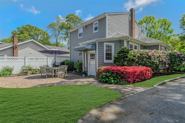 935 Harrison Dr, Centerport, NY 11721 - rear view of house with a patio and a chimney