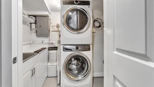 19 Barstow Rd Unit G, Great Neck, NY 11021 - laundry room featuring estacked washer and dryer, electric panel, light tile patterned flooring, and a sink