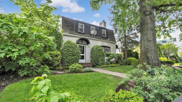 19 Barstow Rd Unit G, Great Neck, NY 11021 - view of front of property featuring mansard roof, a front yard, brick siding, a chimney, and entry steps