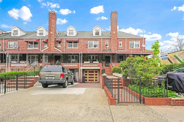 townhome / multi-family property featuring stairs, a chimney, driveway, a garage, and brick siding