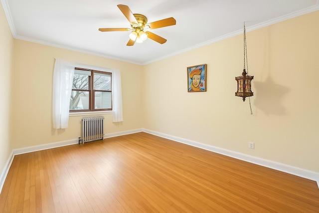 empty room featuring radiator, wood finished floors, baseboards, a ceiling fan, and ornamental molding
