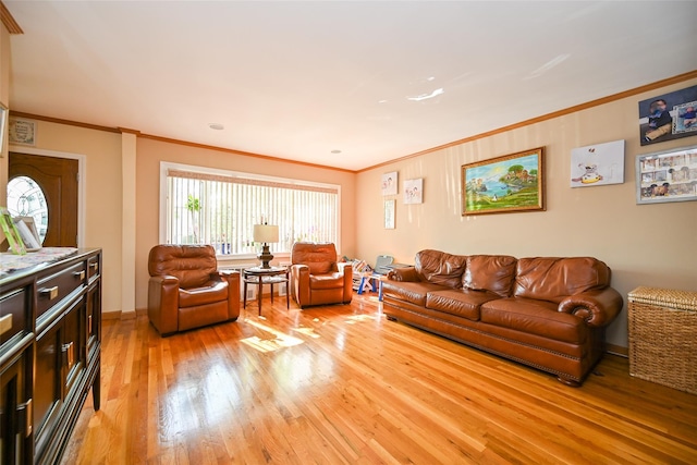 living area with ornamental molding, light wood-style flooring, and baseboards