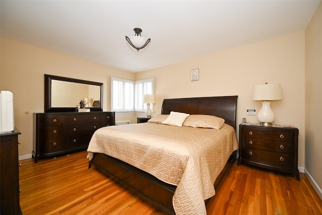bedroom featuring wood finished floors and baseboards