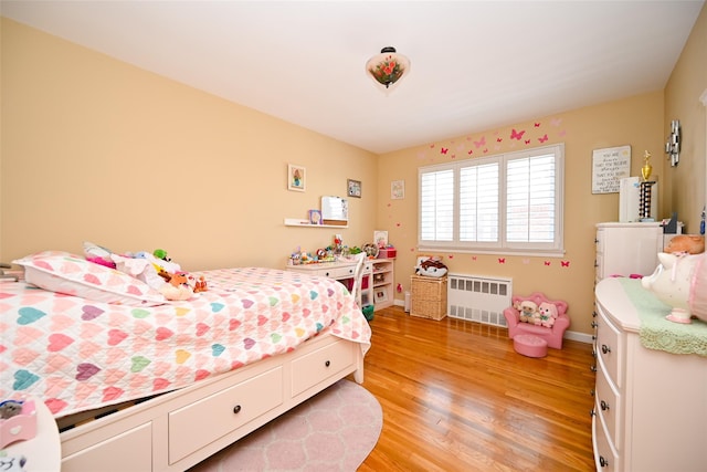 bedroom with radiator and light wood-style floors