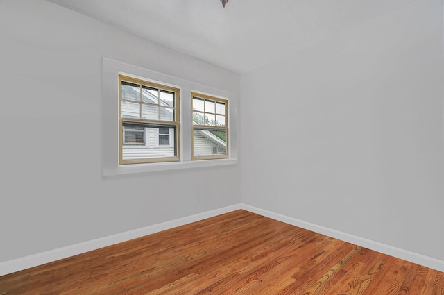 spare room with wood finished floors and baseboards