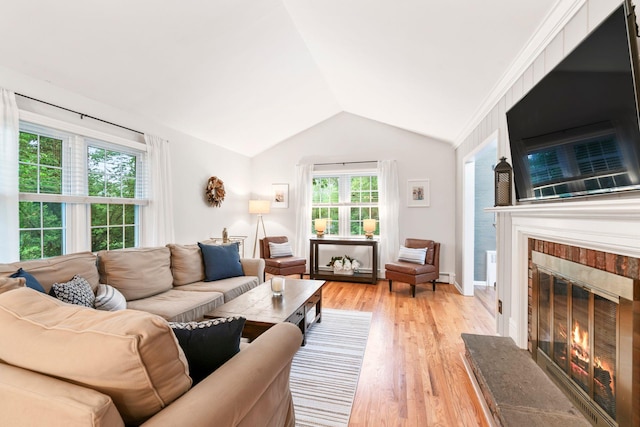 living room with lofted ceiling, a fireplace, light wood-style flooring, and a baseboard heating unit