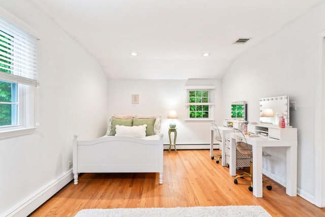 bedroom featuring baseboard heating, a baseboard radiator, wood finished floors, lofted ceiling, and a desk