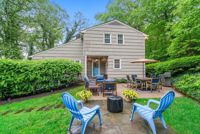 back of house with a patio, a fire pit, and a yard