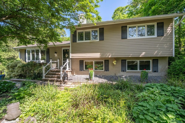 10 Falcon Pl, Huntington, NY 11743 - tri-level home with a chimney and brick siding