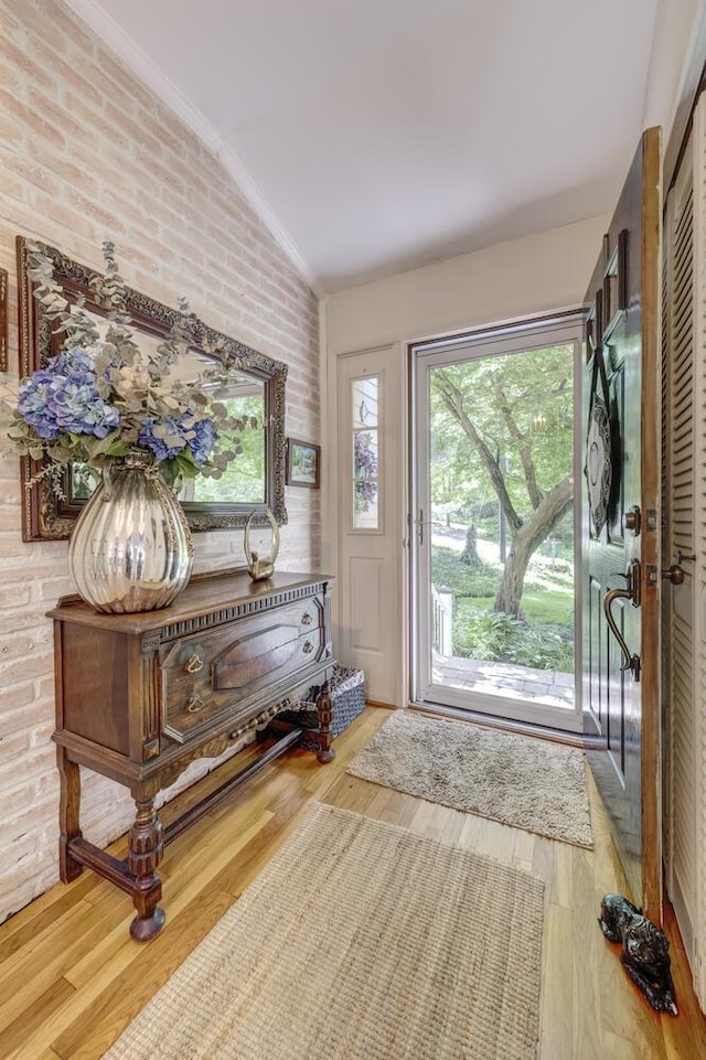 10 Falcon Pl, Huntington, NY 11743 - foyer featuring vaulted ceiling, brick wall, crown molding, and wood finished floors