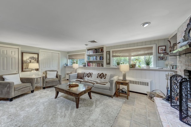 10 Falcon Pl, Huntington, NY 11743 - living area with radiator heating unit, a brick fireplace, and tile patterned flooring