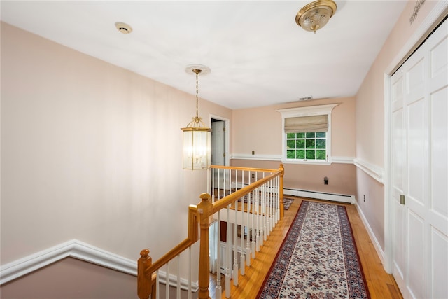 17 Stonegate Dr, Hyde Park, NY 12538 - corridor featuring an upstairs landing, a baseboard radiator, light wood finished floors, a chandelier, and baseboards