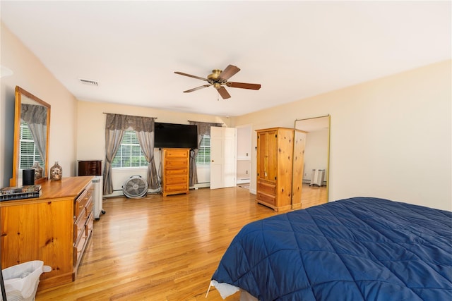 17 Stonegate Dr, Hyde Park, NY 12538 - bedroom with light wood-type flooring, a baseboard heating unit, and a ceiling fan