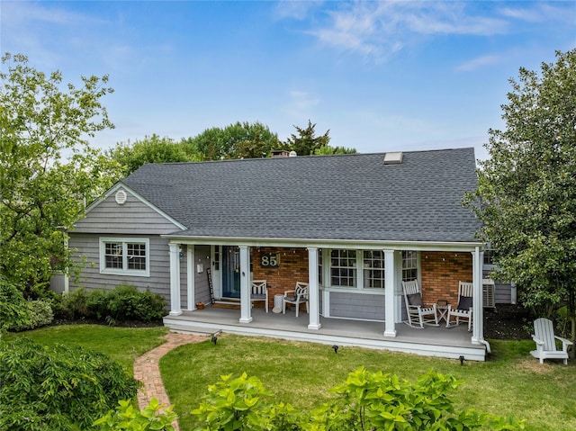 85 Shore Rd, Amityville, NY 11701 - back of property featuring a porch, roof with shingles, a lawn, and brick siding