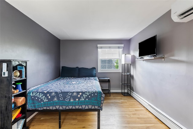 85 Shore Rd, Amityville, NY 11701 - bedroom featuring a wall mounted AC, baseboard heating, wood finished floors, a baseboard heating unit, and baseboards