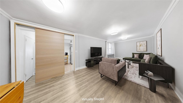 living area featuring ornamental molding, light wood-style floors, and baseboards