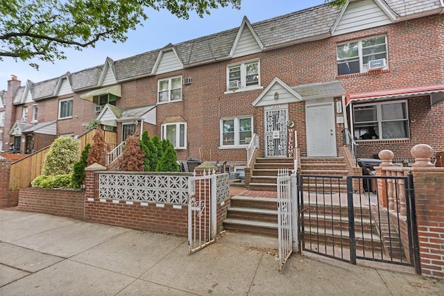 25-36 83rd St, East Elmhurst, NY 11370 - townhome / multi-family property with a high end roof, brick siding, a fenced front yard, and a gate