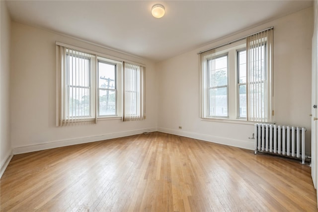 1175 E Broadway Unit 2J, Hewlett, NY 11557 - spare room featuring radiator heating unit, light wood-style floors, and baseboards