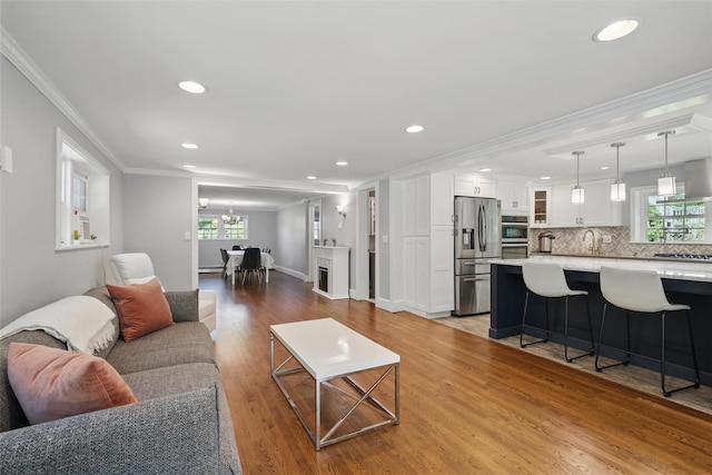 8 Clinton Ct, Monroe, NY 10950 - living area with ornamental molding, wood finished floors, recessed lighting, plenty of natural light, and a chandelier
