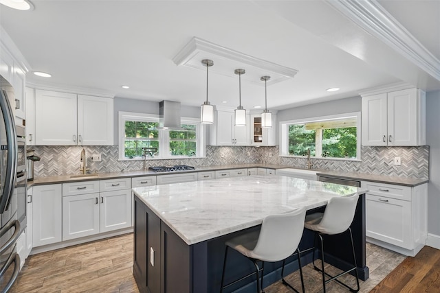 8 Clinton Ct, Monroe, NY 10950 - kitchen with stainless steel gas cooktop, white cabinets, light wood-type flooring, a kitchen island, and tasteful backsplash