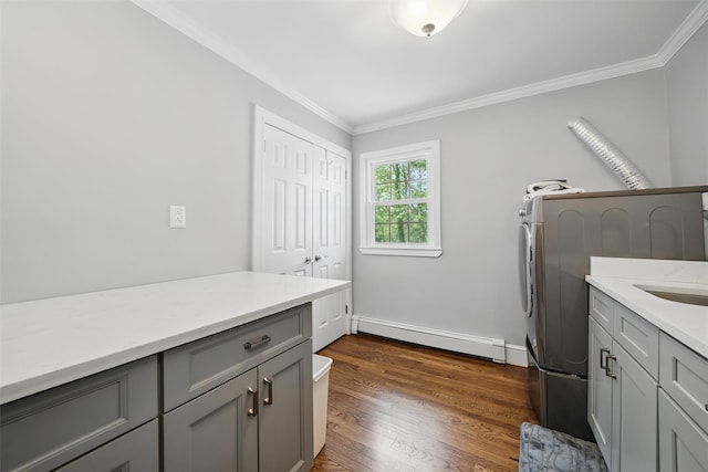 8 Clinton Ct, Monroe, NY 10950 - laundry area featuring baseboard heating, cabinet space, ornamental molding, dark wood-type flooring, and baseboards