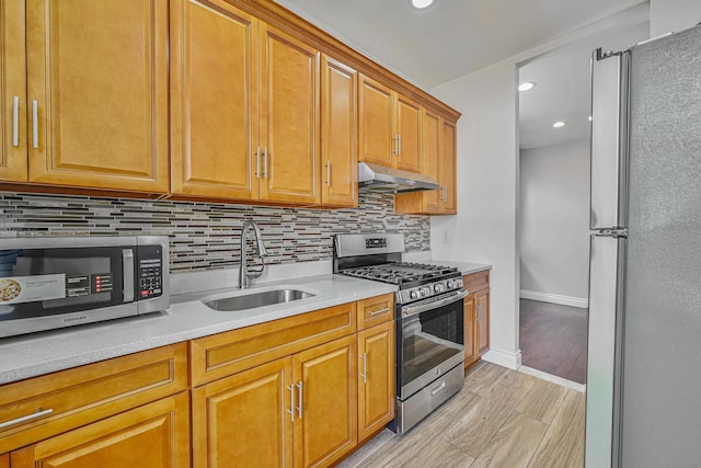 5130 35th St, Long Island City, NY 11101 - kitchen with stainless steel appliances, under cabinet range hood, a sink, tasteful backsplash, and baseboards