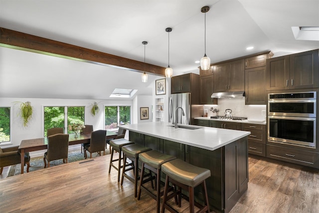 42 Raspberry Ln, Carmel, NY 10512 - kitchen featuring appliances with stainless steel finishes, a skylight, under cabinet range hood, and a breakfast bar area
