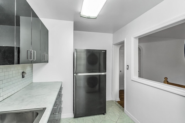 219-36 75th Ave Unit 243A2, Bayside, NY 11364 - kitchen with freestanding refrigerator, backsplash, light countertops, baseboards, and a sink