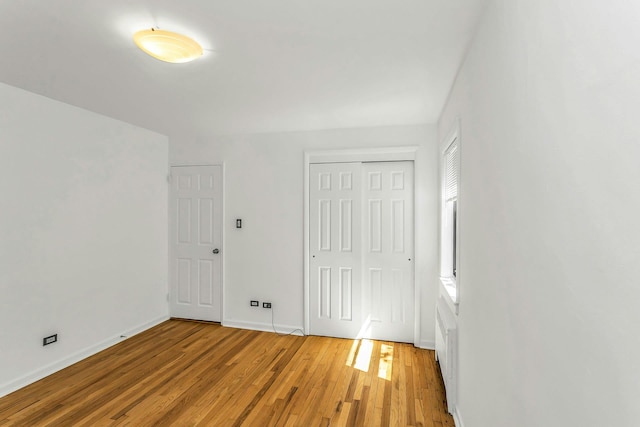 219-36 75th Ave Unit 243A2, Bayside, NY 11364 - unfurnished bedroom with light wood-style floors, baseboards, and a closet