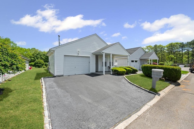 view of front of house with a garage, a front yard, and driveway