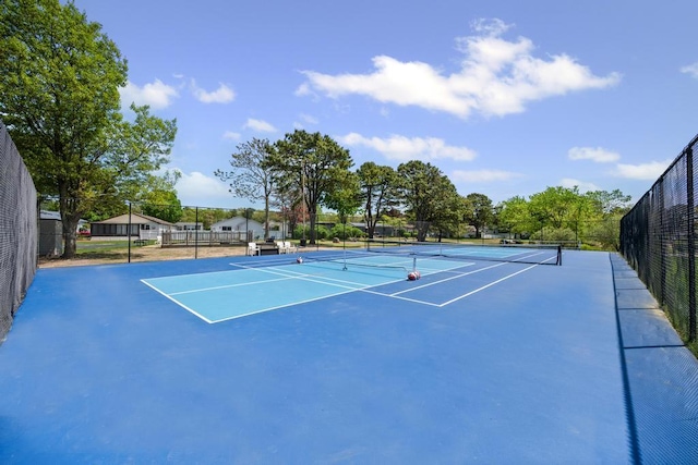 view of tennis court with community basketball court and fence