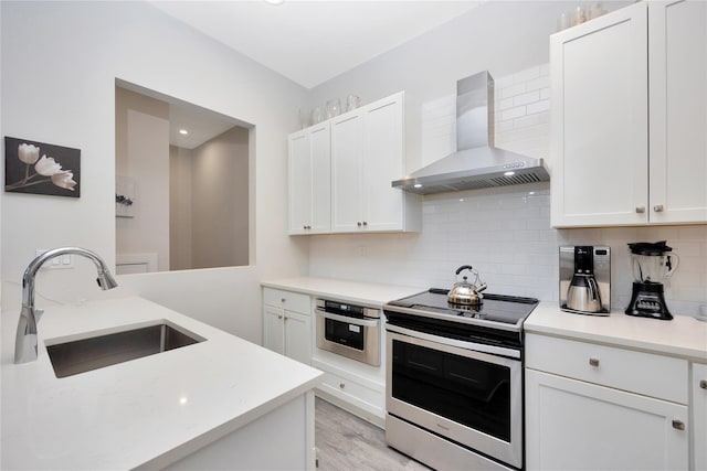 308 Breton Way Unit 308, Glen Cove, NY 11542 - kitchen with wall chimney exhaust hood, stainless steel appliances, a sink, light countertops, and tasteful backsplash