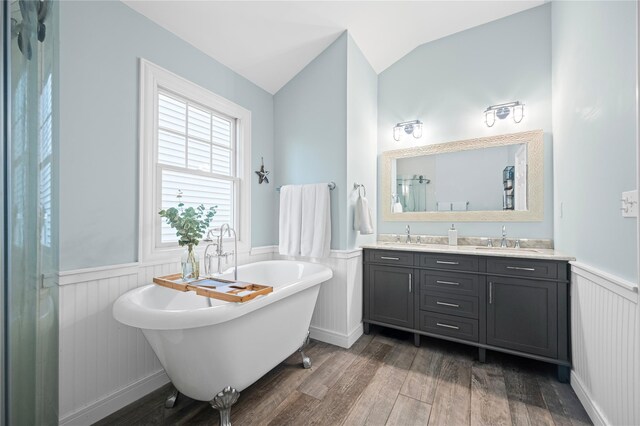 49 Oregon St, Long Beach, NY 11561 - bathroom with a wainscoted wall, wood finished floors, a soaking tub, double vanity, and lofted ceiling