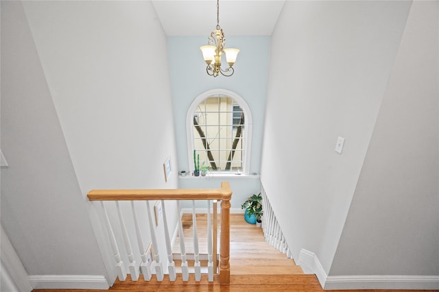 49 Oregon St, Long Beach, NY 11561 - stairway featuring a chandelier, wood finished floors, and baseboards