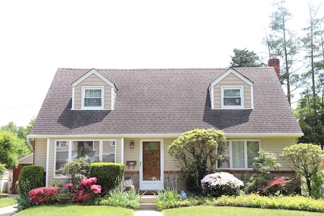 cape cod home with a chimney and a shingled roof