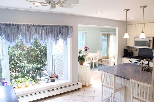 dining room featuring ceiling fan, a baseboard heating unit, light tile patterned floors, and recessed lighting