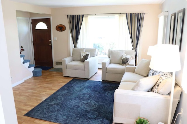 living room with wood finished floors, stairs, and baseboards