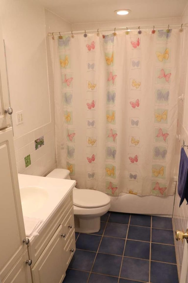 bathroom featuring tile patterned flooring, toilet, vanity, and shower / tub combo