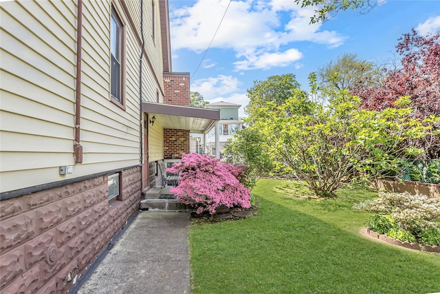 view of grassy yard with a porch