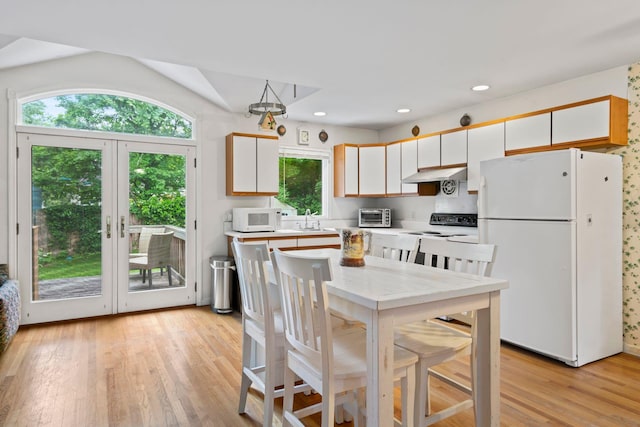 90 Cocks Ln, Locust Valley, NY 11560 - kitchen with white appliances, under cabinet range hood, a sink, white cabinets, and light wood finished floors