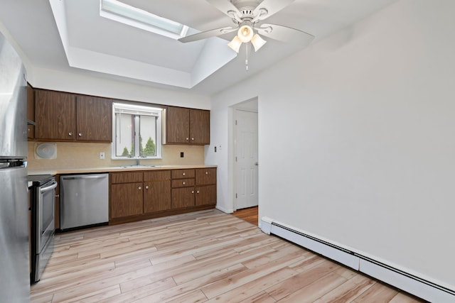 90 Cocks Ln, Locust Valley, NY 11560 - kitchen featuring appliances with stainless steel finishes, a baseboard heating unit, a sink, light countertops, and a tray ceiling