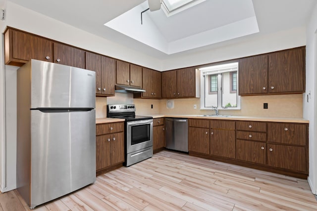 90 Cocks Ln, Locust Valley, NY 11560 - kitchen featuring stainless steel appliances, under cabinet range hood, a skylight, light countertops, and a sink