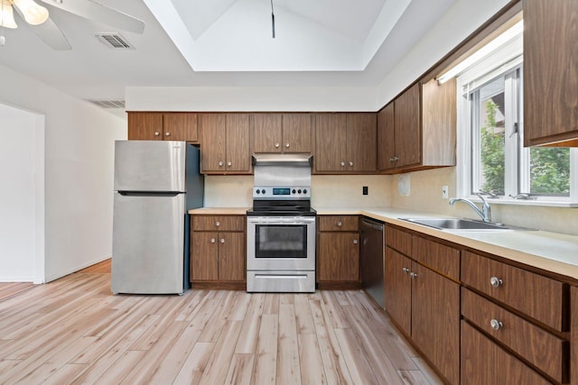90 Cocks Ln, Locust Valley, NY 11560 - kitchen featuring appliances with stainless steel finishes, a sink, light wood-style floors, under cabinet range hood, and light countertops