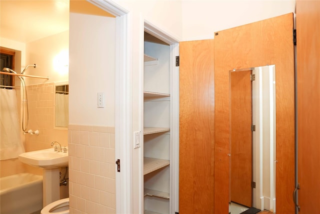 808 Bronx River Rd Unit 1A, Yonkers, NY 10708 - bathroom with tile walls, shower / bath combo with shower curtain, a wainscoted wall, and toilet