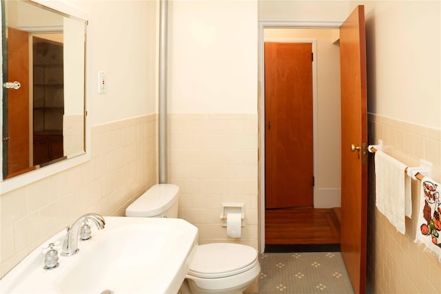 808 Bronx River Rd Unit 1A, Yonkers, NY 10708 - bathroom featuring tile walls, a sink, toilet, wainscoting, and tile patterned floors