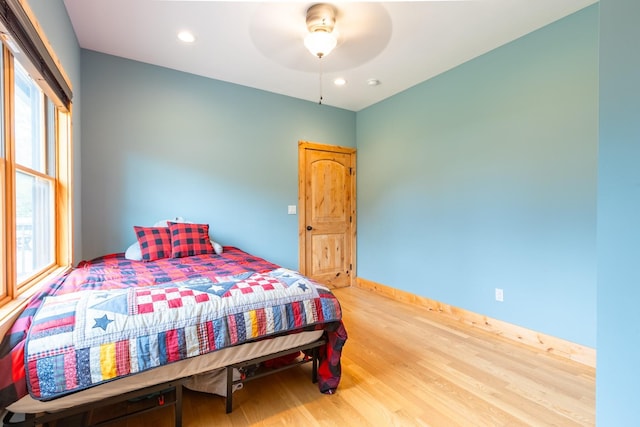 bedroom with wood finished floors, multiple windows, recessed lighting, baseboards, and a ceiling fan