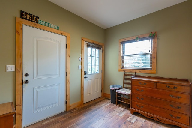 doorway to outside with light wood finished floors and baseboards